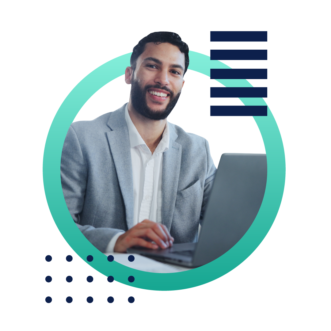 A business man in a gray suit smiling and using a laptop as his desk, inside of a designed green circle.