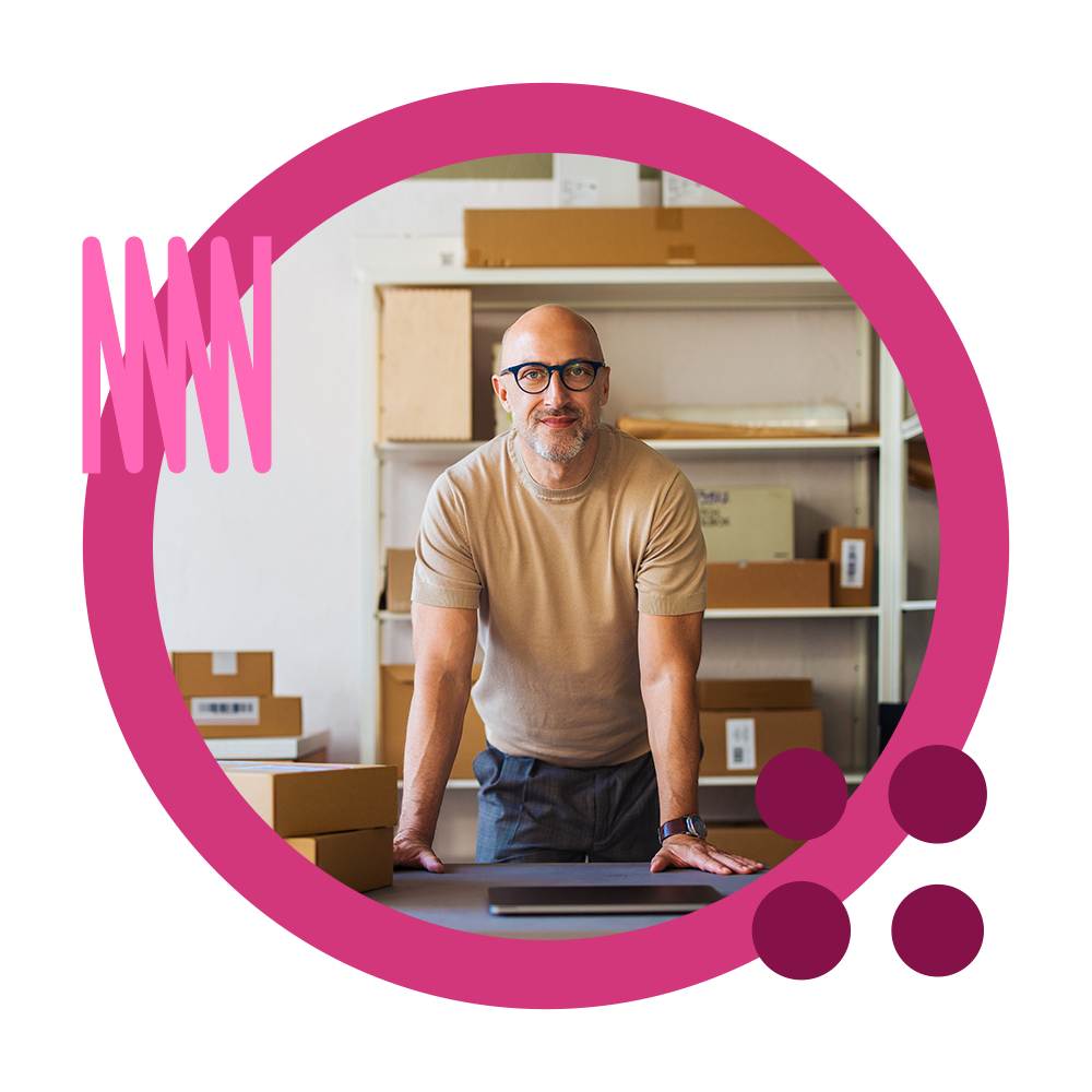 A businessman using his laptop for B2B ecommerce solutions including order punchout in a warehouse with boxes.